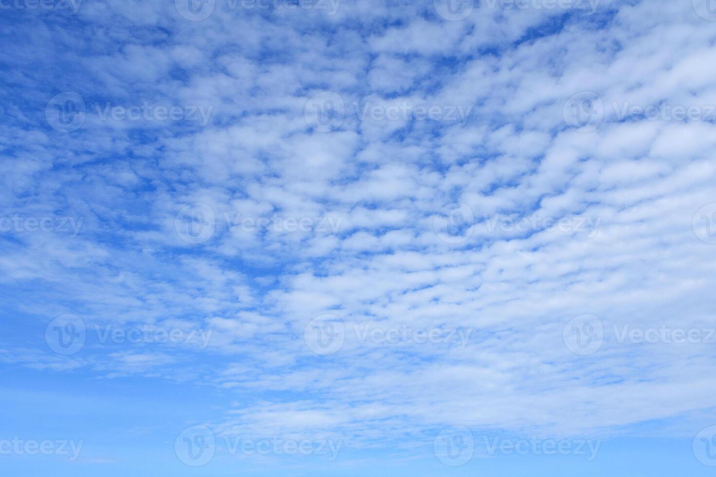 White clouds in bright blue sky as background photo