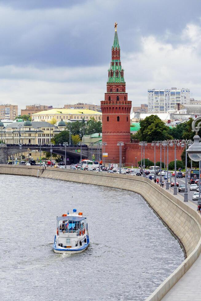 Moscow, Russia, August, 2018 View of the Kremlin Embankment with a pleasure boat sailing along the river photo