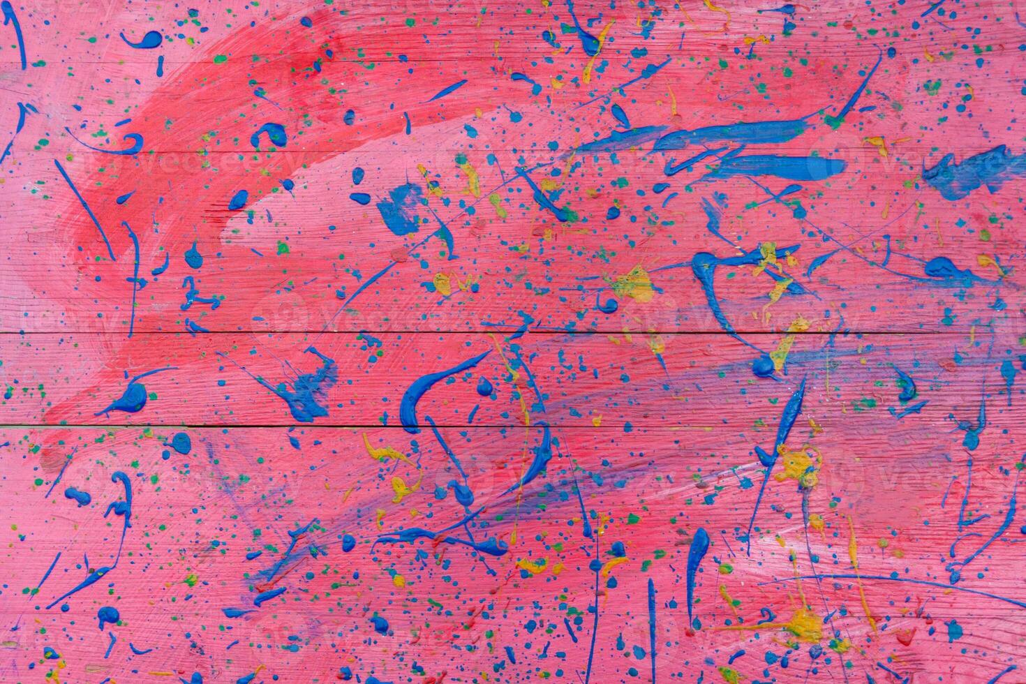 Abstract view of a red wooden board with blue paint stains as background, texture photo