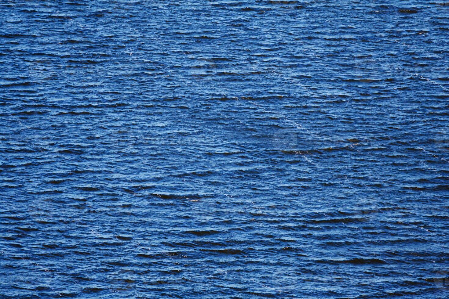 Deep blue water with small waves as background, texture photo