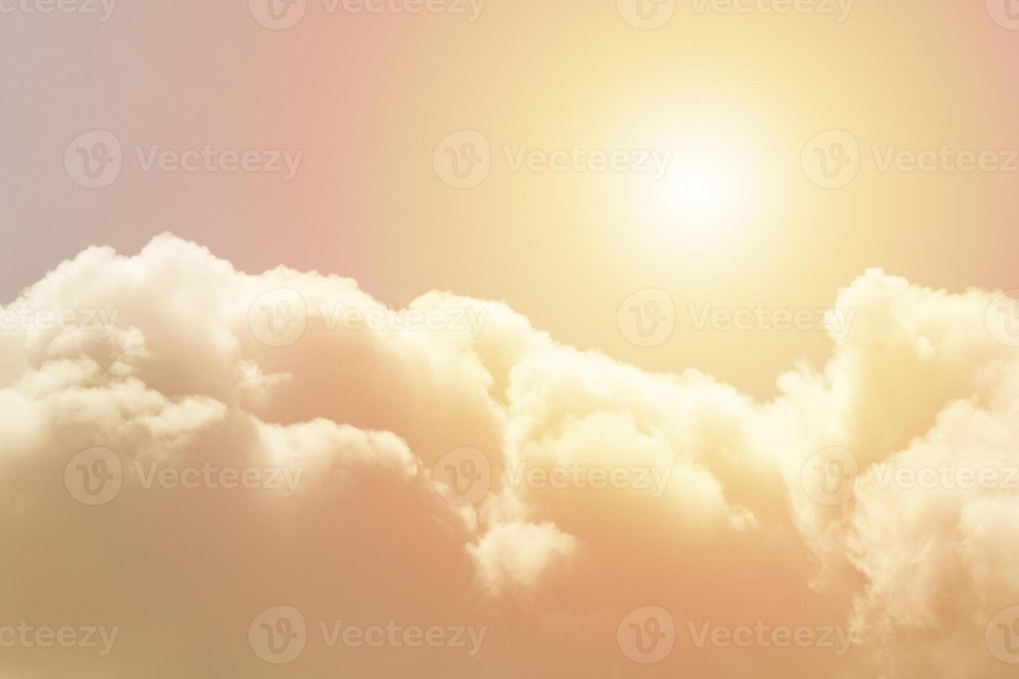 Cumulus fluffy clouds illuminated by the sun against a orange sky photo