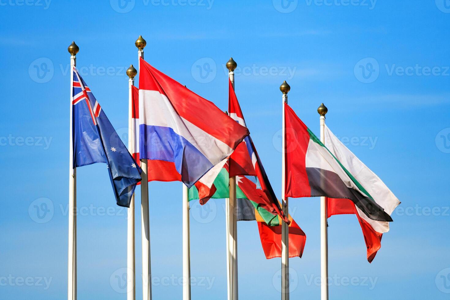 Flags of different countries flutters in the wind a background of blue sky photo