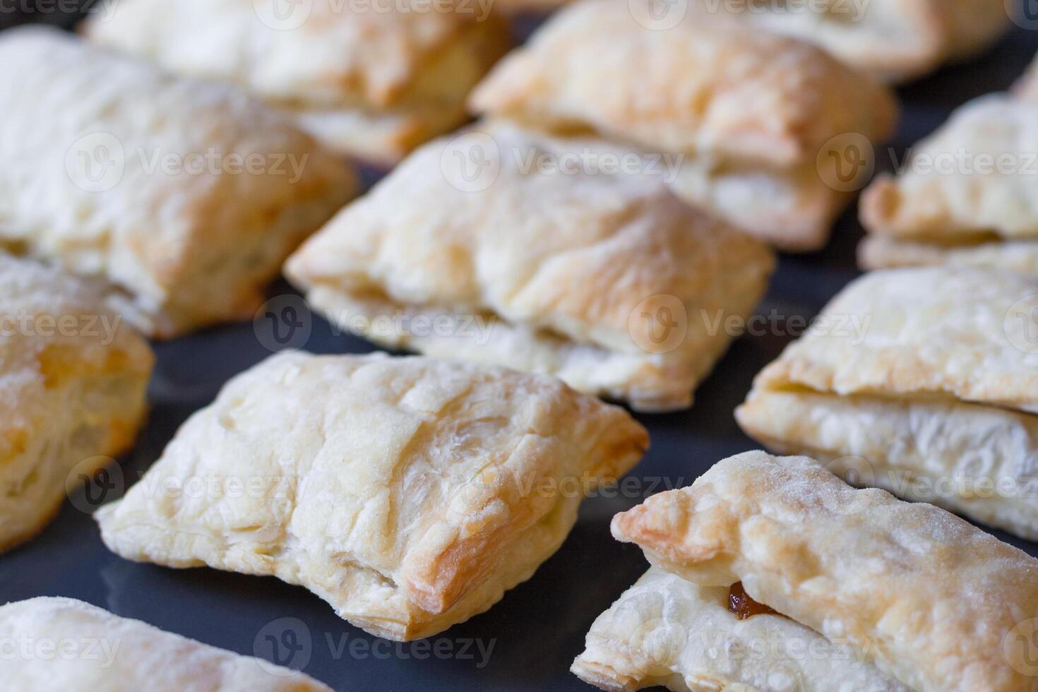 Close up view of a freshly baked pies made of puff pastry on a baking sheet photo