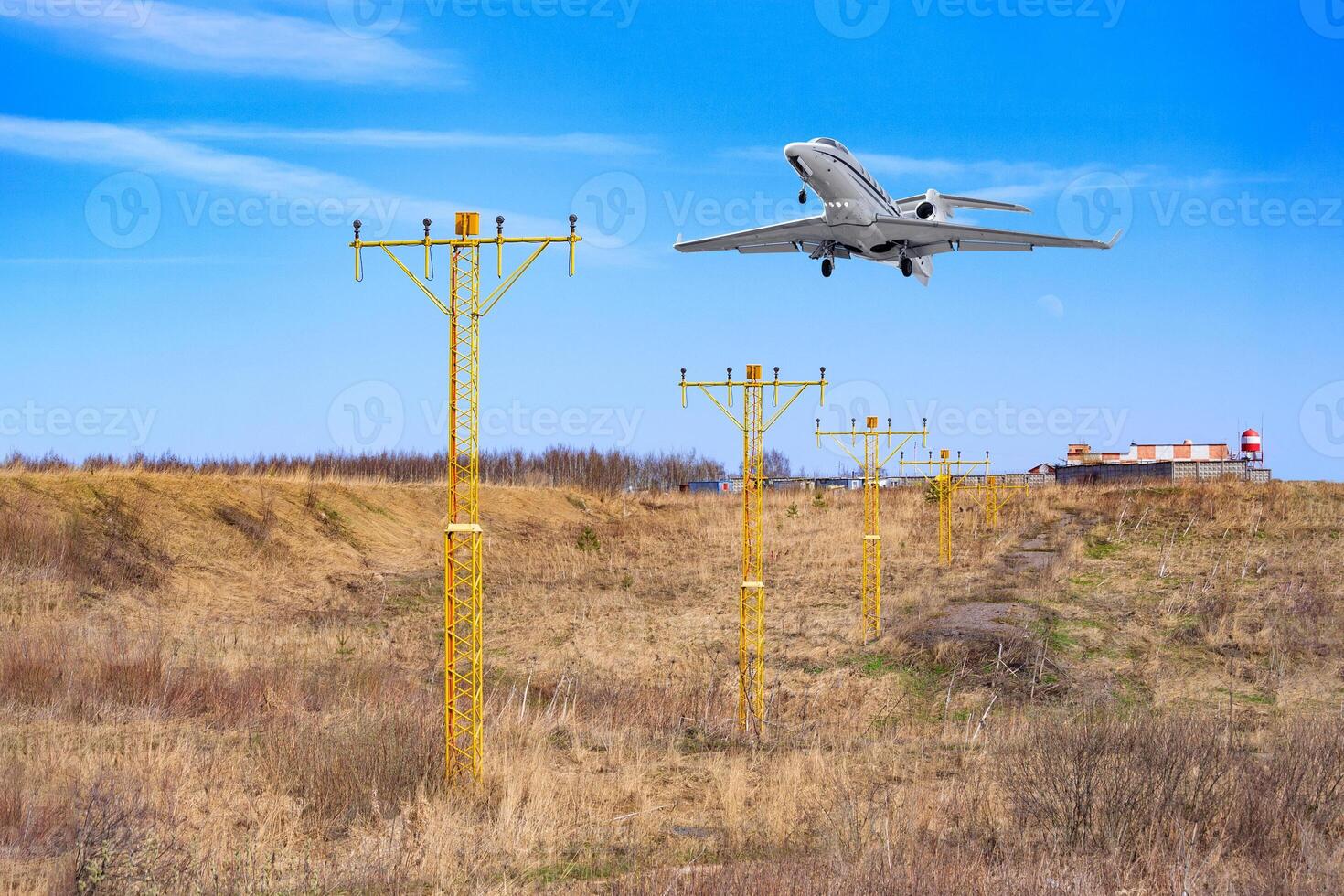 The aircraft prepare to landing, flying above the metal supports with navigation signal lights photo