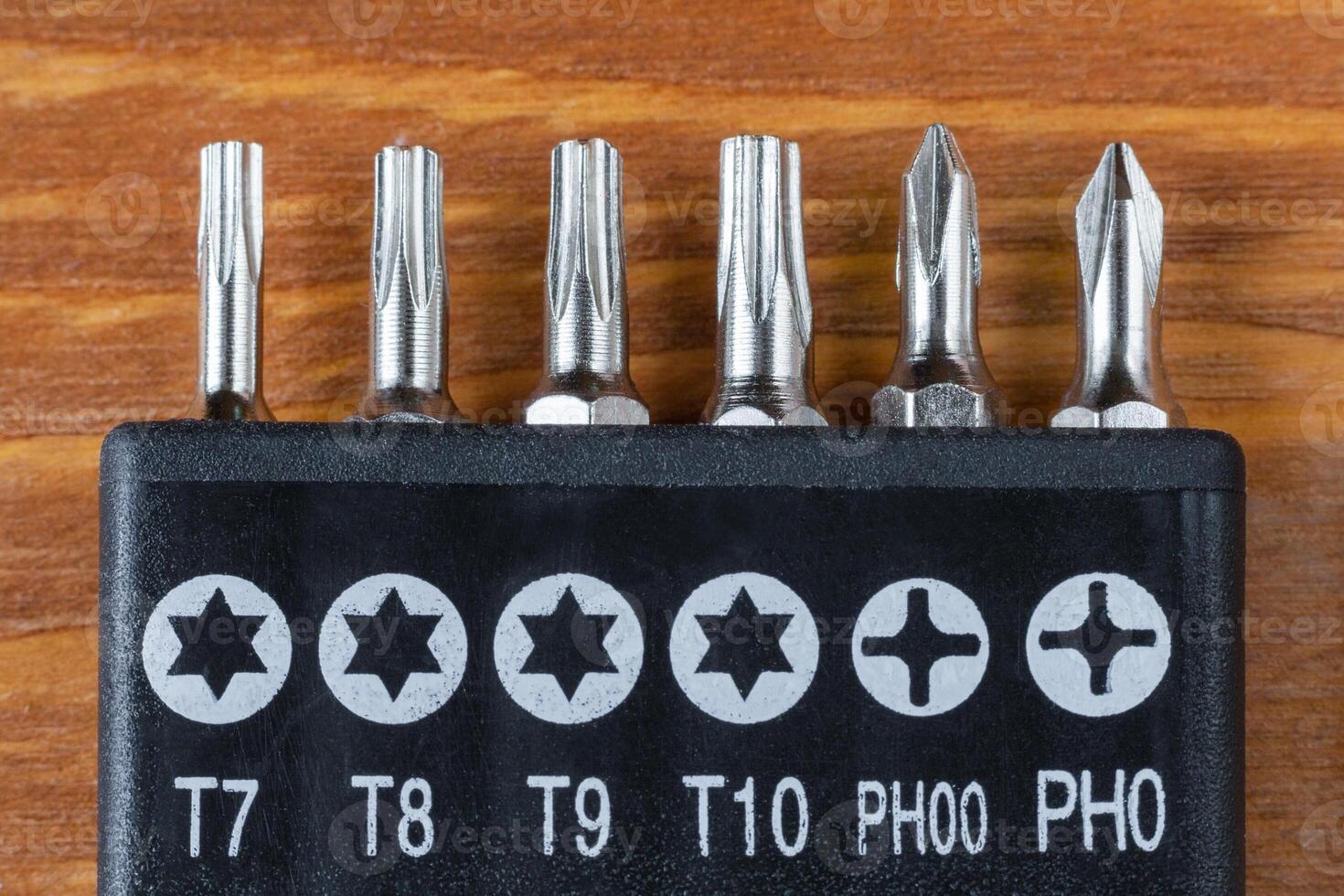 Set of heads for screwdriver bits on a wooden table photo