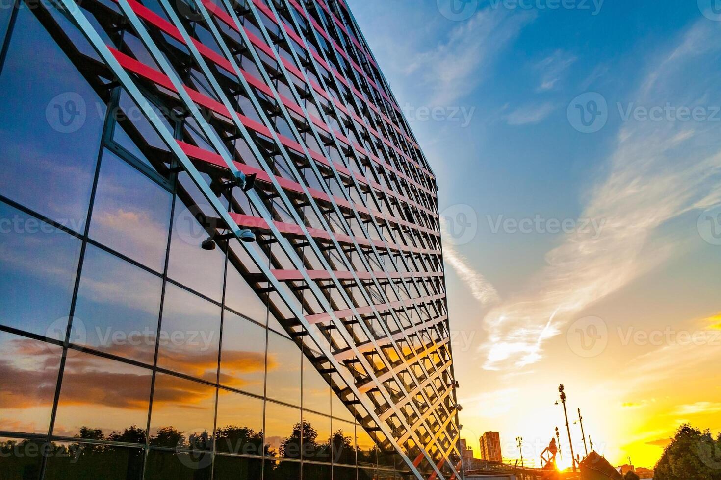 Perspective view of a fragment of the facade of a modern building of glass and iron on a sunset sky background photo