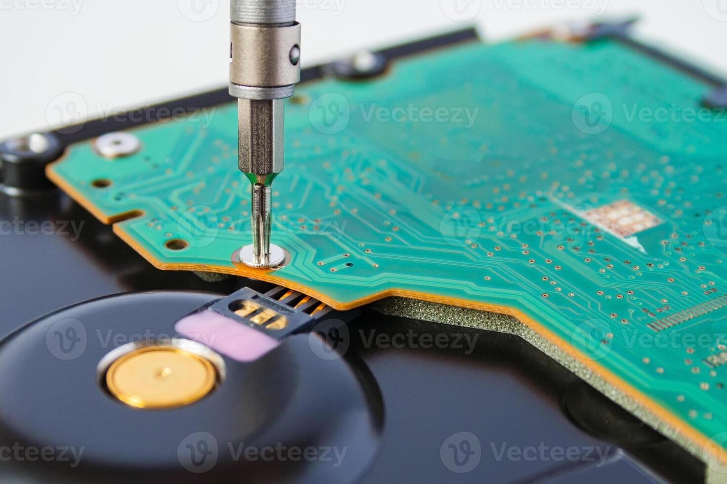 Closeup view of a use a screwdriver to open the screws on the hard drive. Computer repair. photo