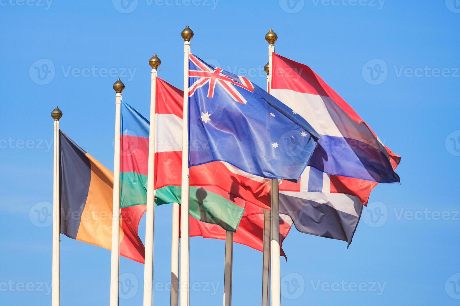 Flags of different countries flutters in the wind a background of bright blue sky photo