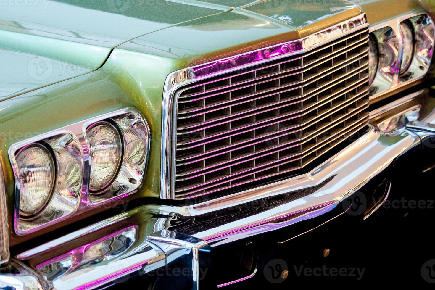 Exhibition of retro cars. Fragment of the front part of the car with round headlights and grille photo