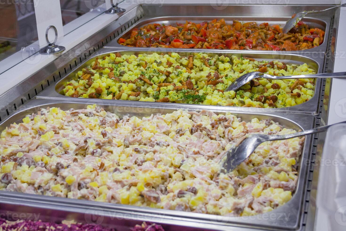 A different multicolored prepared salads on the counter in the store photo