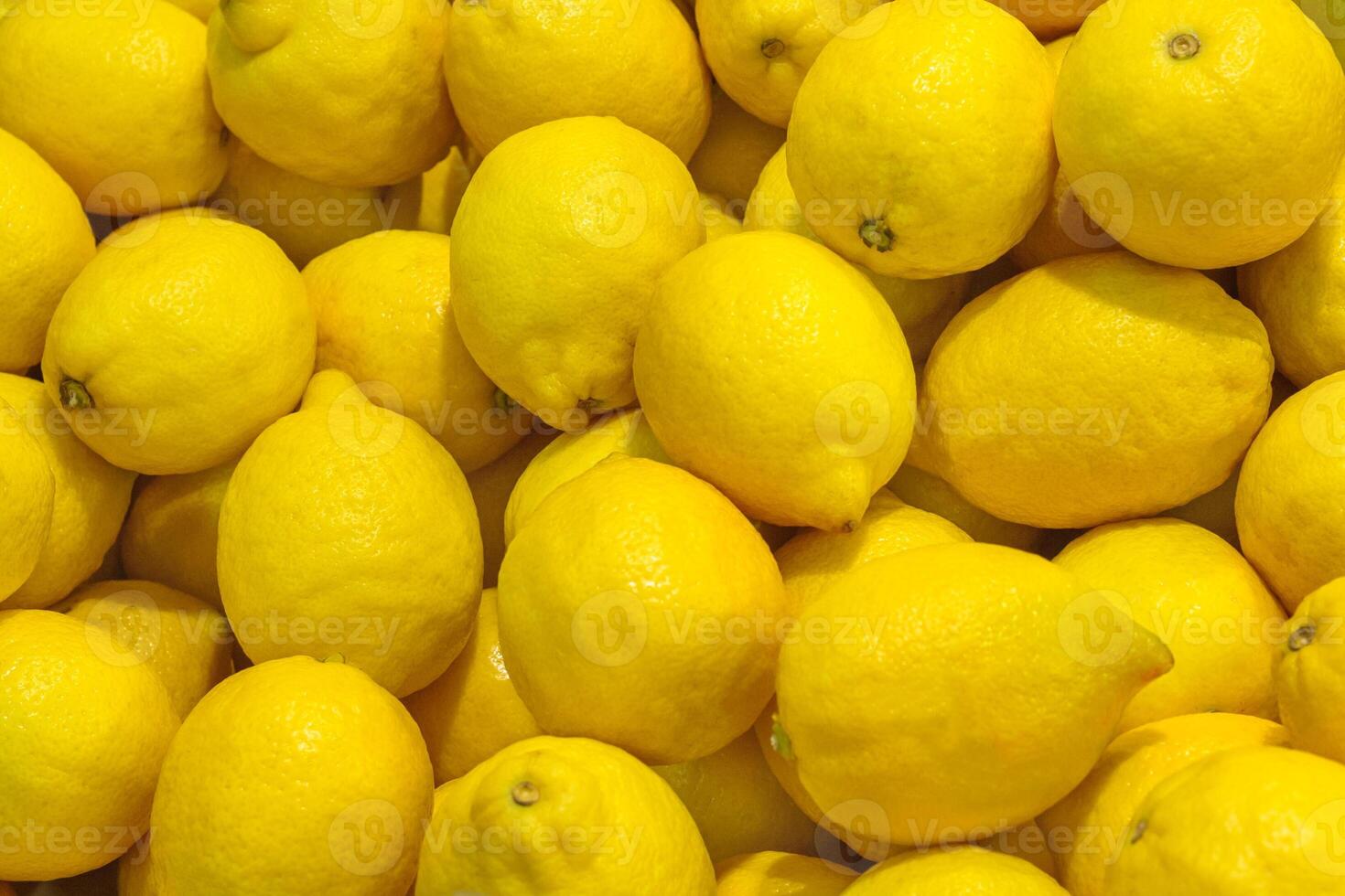 Close up view of a pile of bright yellow lemons as background, texture photo