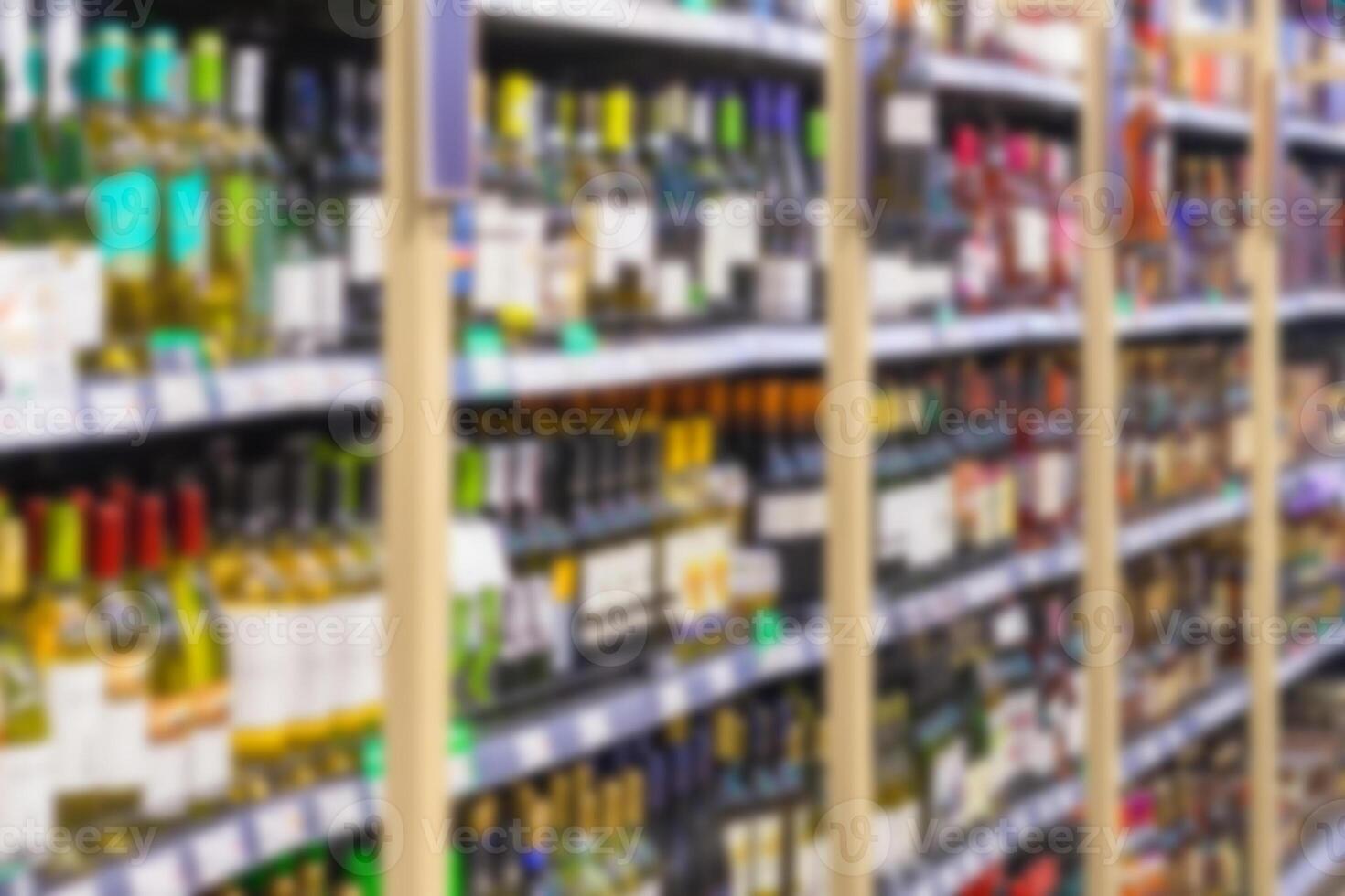 Blurred image of racks with alcoholic drinks in the store. Perspective view. photo