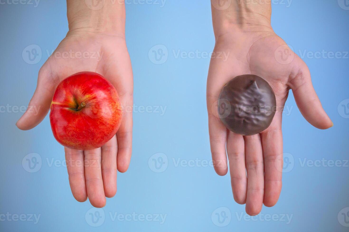 Choice between a red ripe apple and marshmallow in chocolate photo