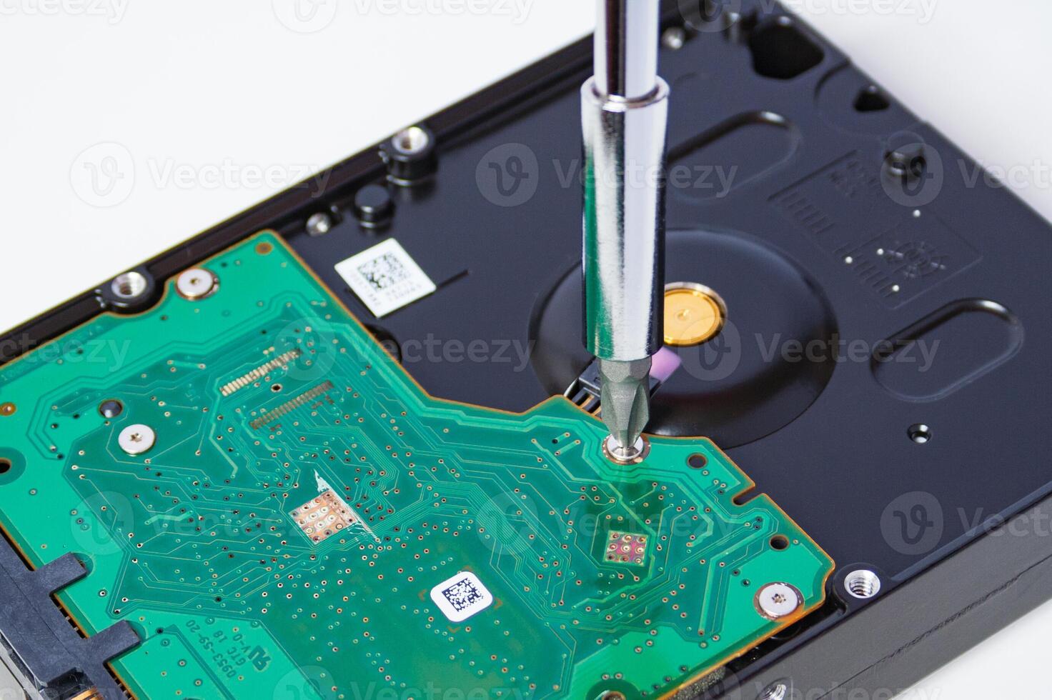 Closeup view of a use a screwdriver to open the screws on the hard drive. Computer repair. photo