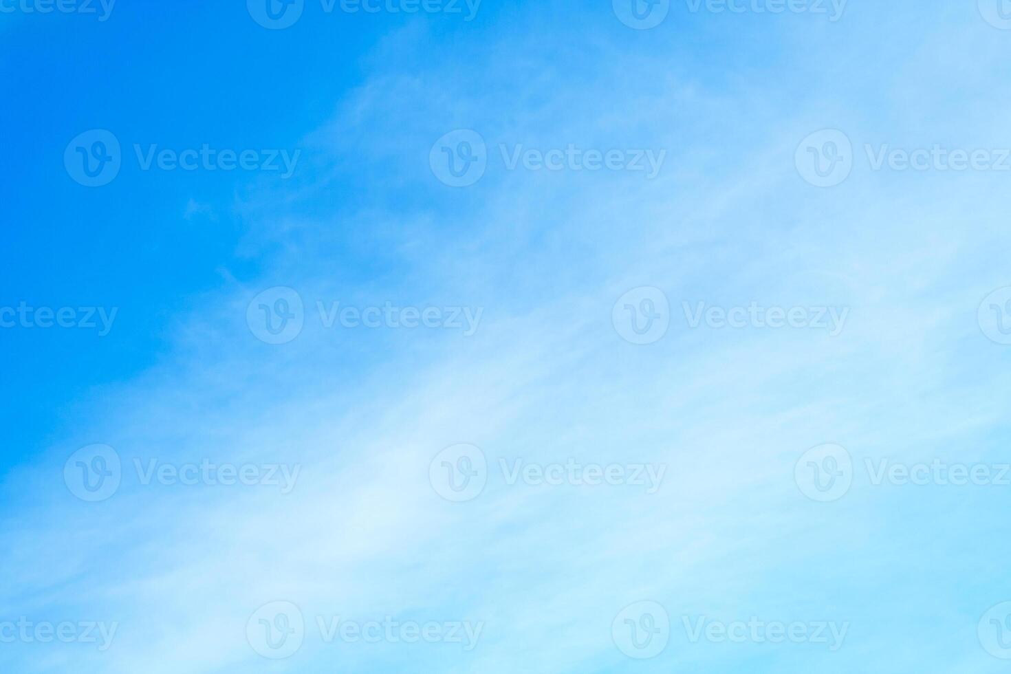 White cirrus clouds in bright azure sky photo