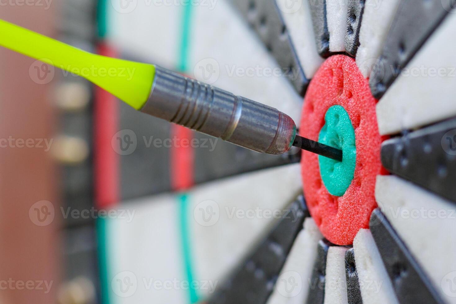 View on a fragment of dartboard with dart in a bullseye photo