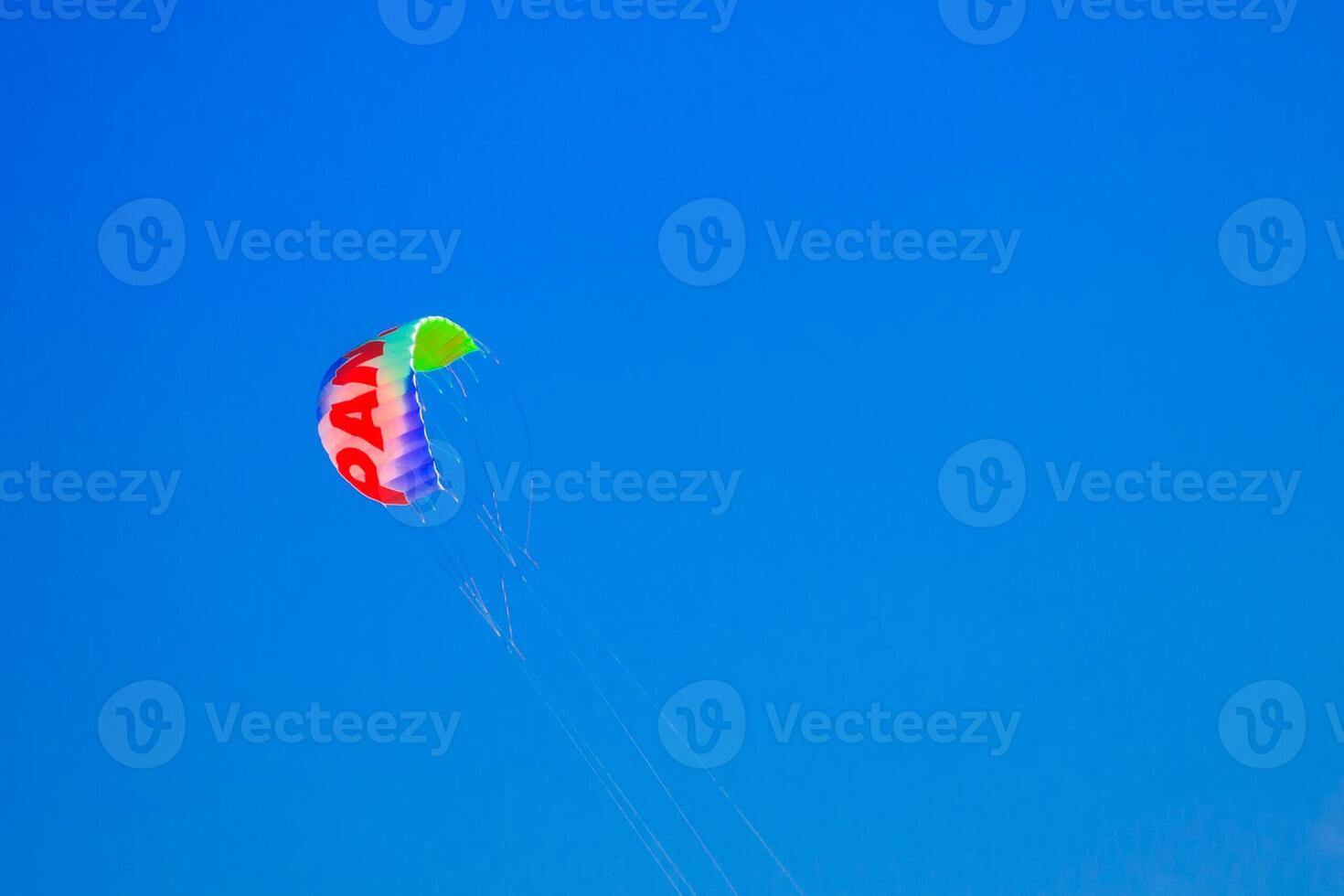 Multicolored parachute in the blue sky photo