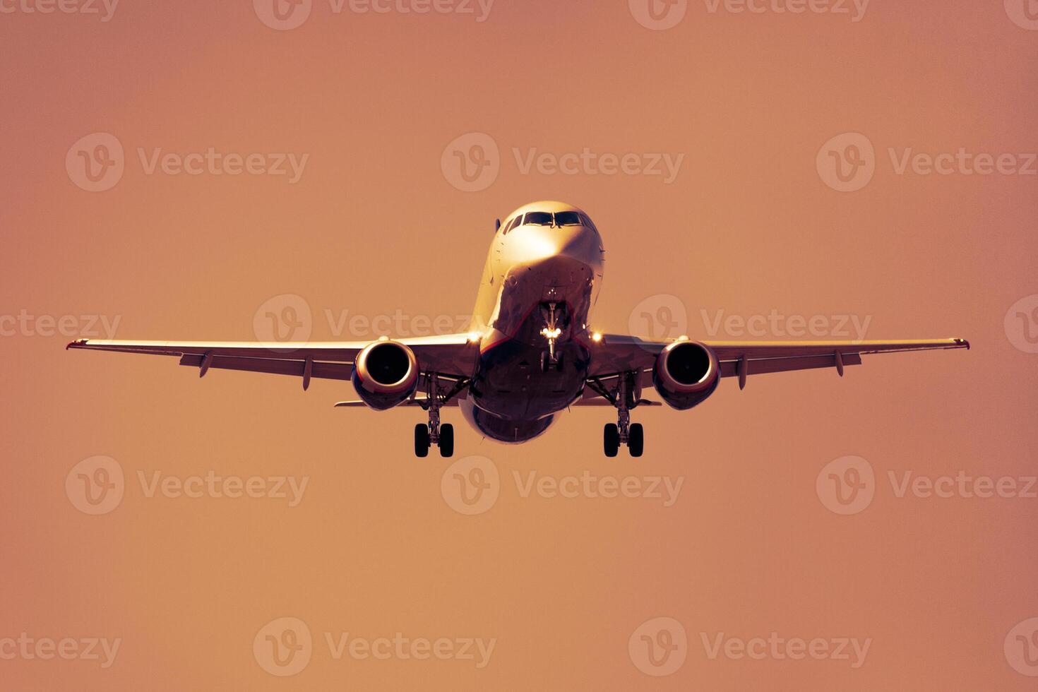 Front view of a aircraft against a orange sunset sky photo