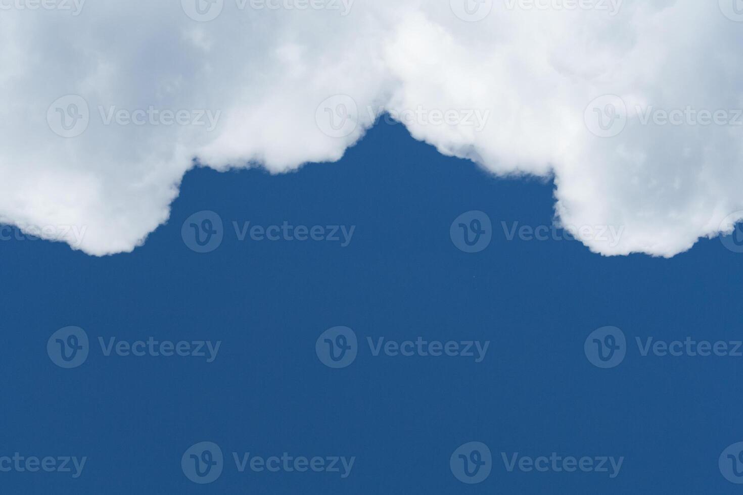 View of white cumulus fluffy clouds against a deep blue sky with copy space photo