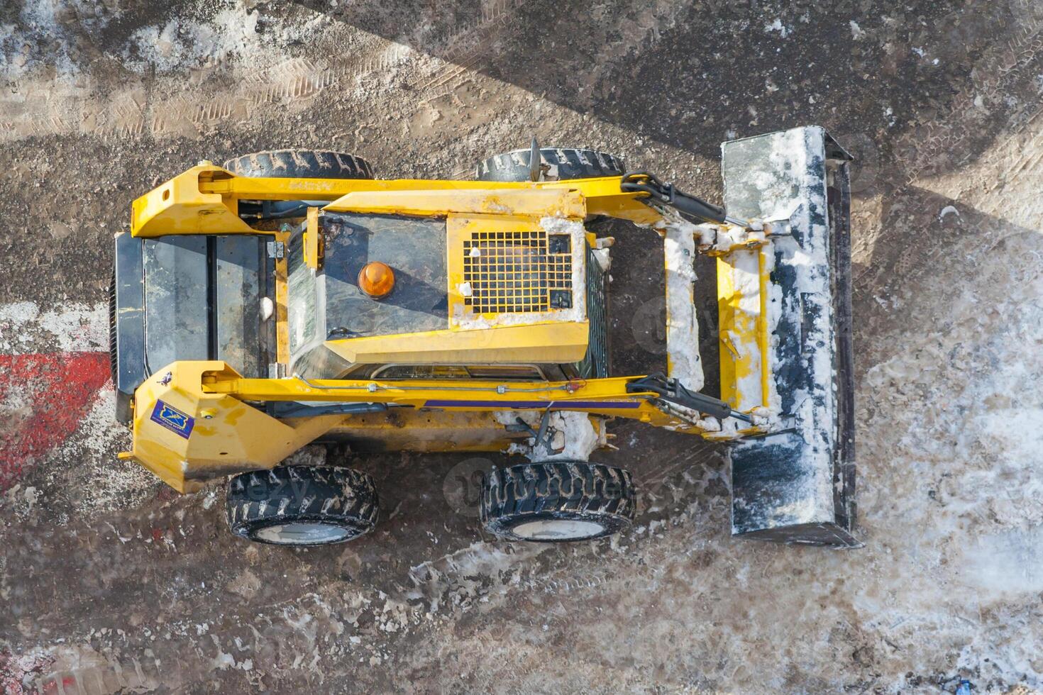 Skid steer loader on a dirty road. Top view photo