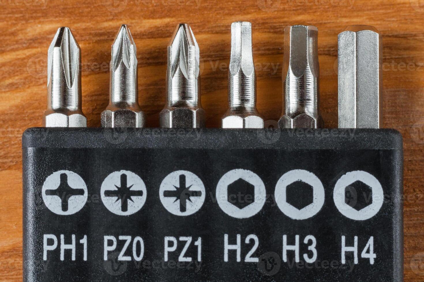 A set of tools collection from heads for screwdriver or bits on a wooden table photo