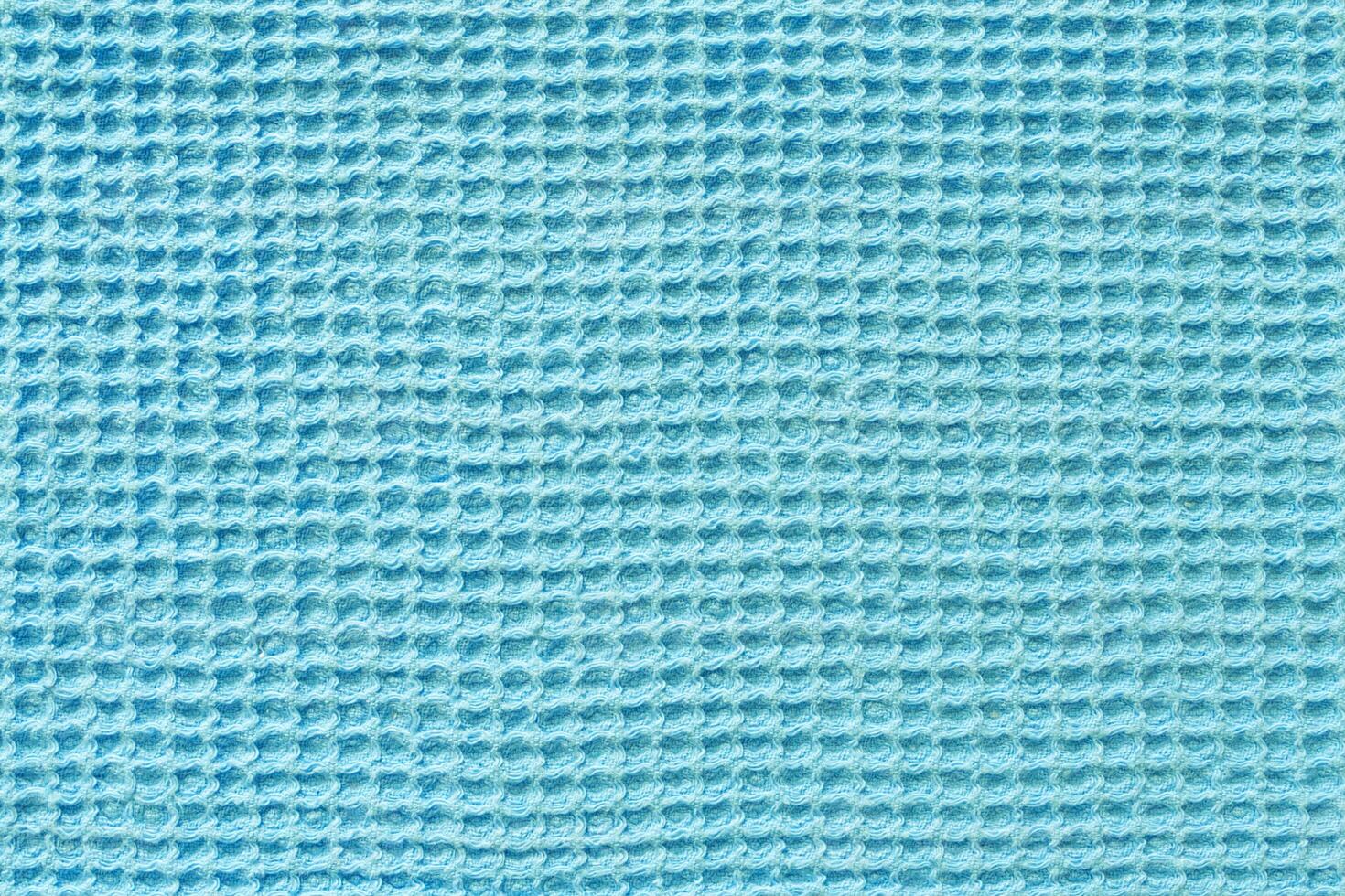 Close up view of a turquoise waffle fabric as background, texture photo