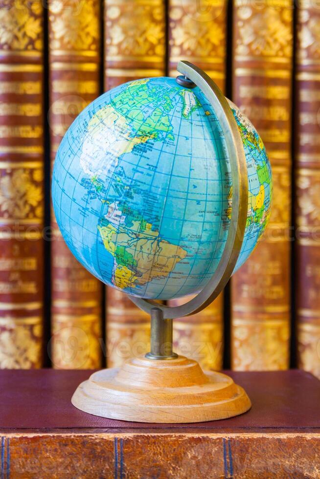 Globe on the background of pile of vintage books. Concept of education, research photo
