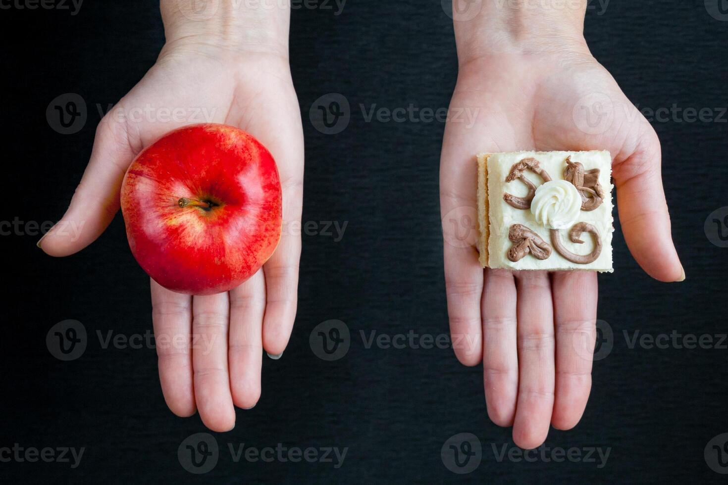Choice between a ripe red apple and a cake with cream photo