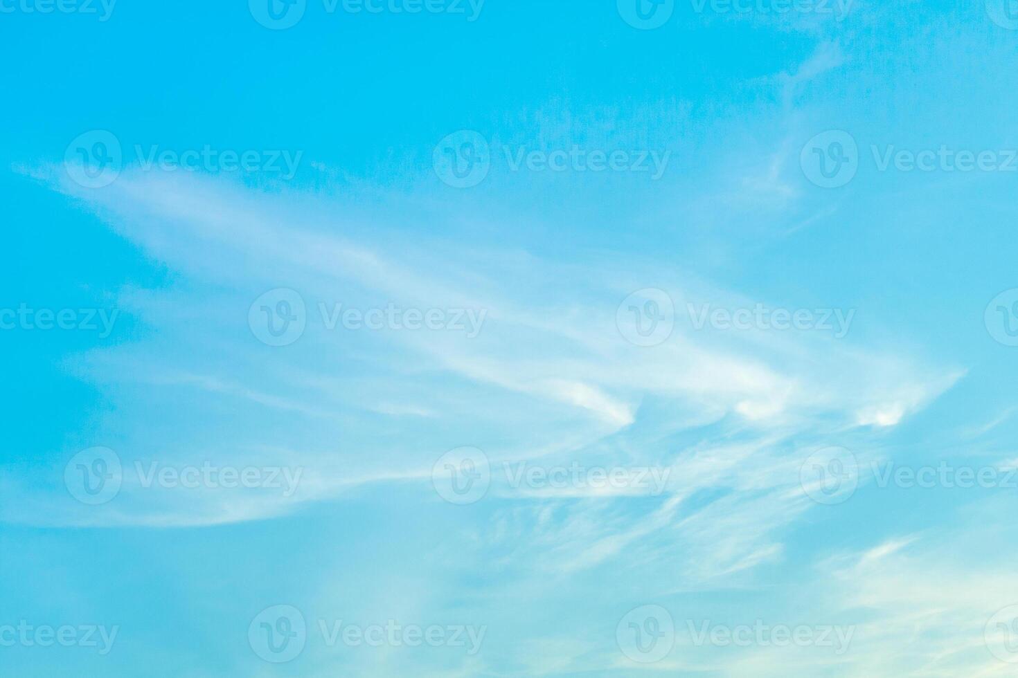 White cirrus clouds in bright turquoise sky as background photo