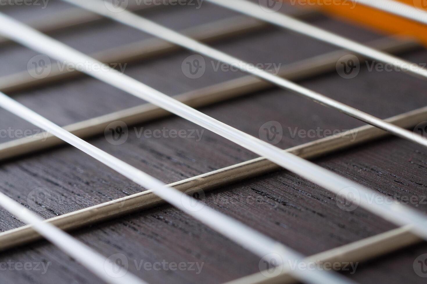 Close up view on a neck of acoustic guitar with strings photo