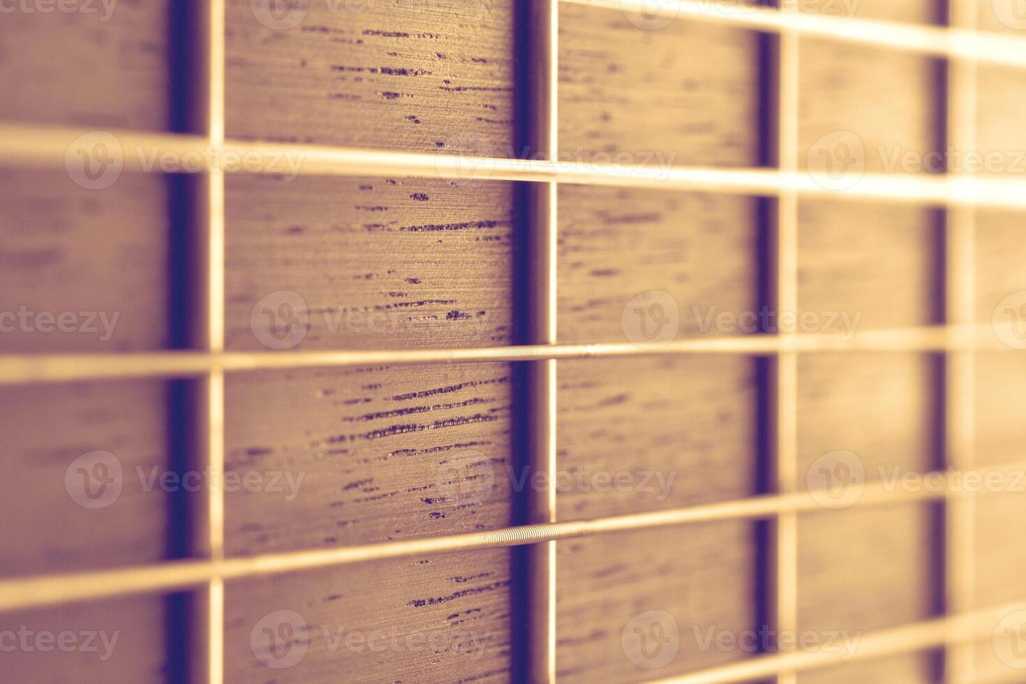 Close up view on a neck of acoustic guitar with strings illuminated by warm light photo