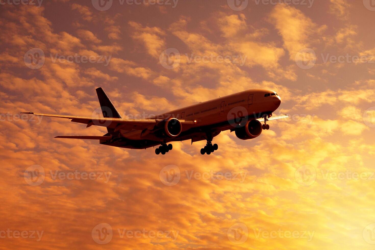 Dramatic view of a dark silhouette of aircraft against a orange clouds in the sunset sky photo