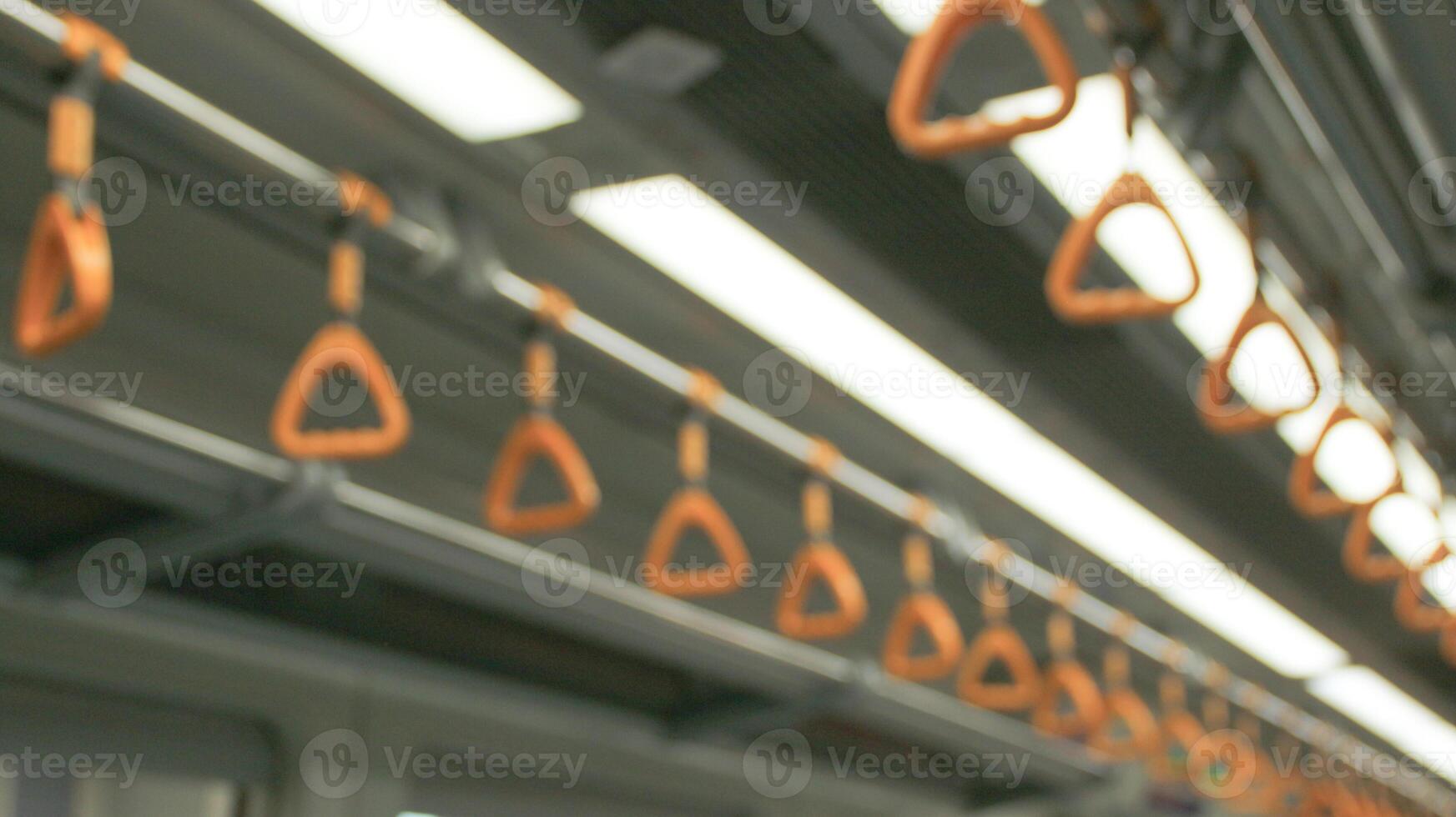 This is a close-up view of some of the yellow passenger handles located inside an LRT train car. photo