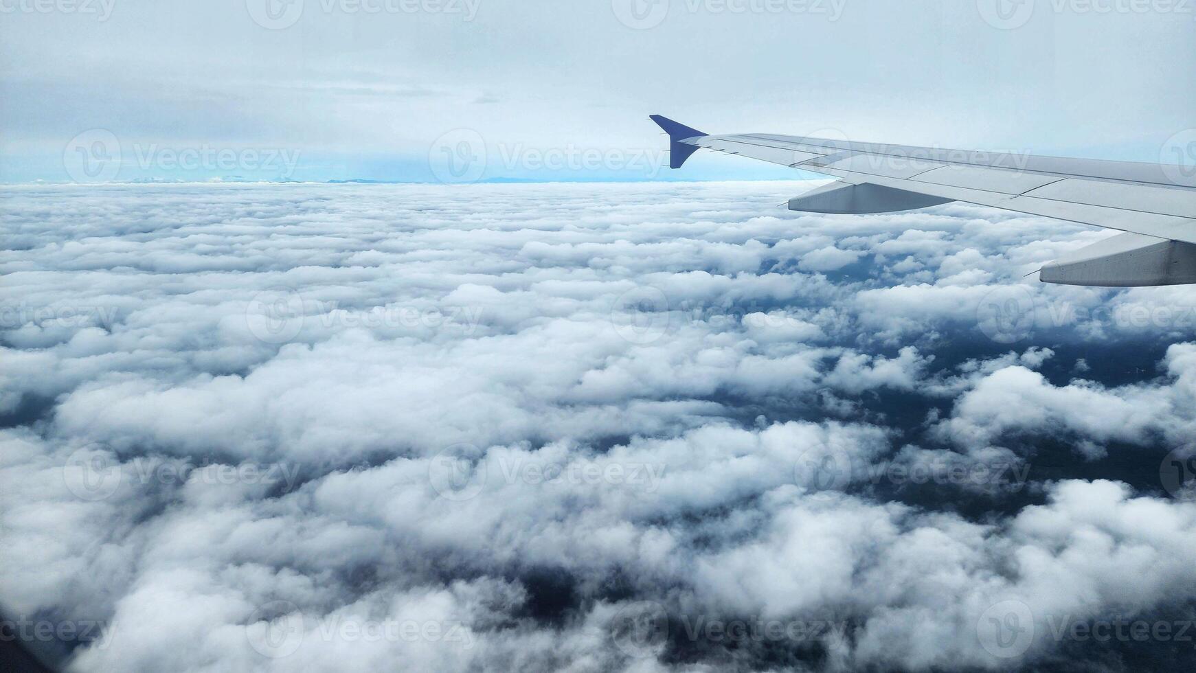 an airplane wing is seen from above the clouds photo
