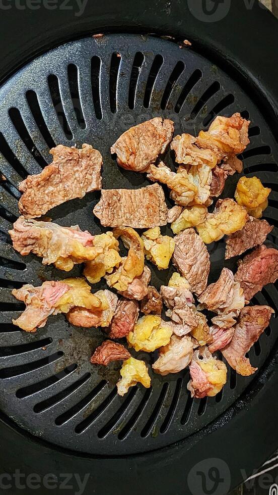 a grill with meat and vegetables cooking on it photo