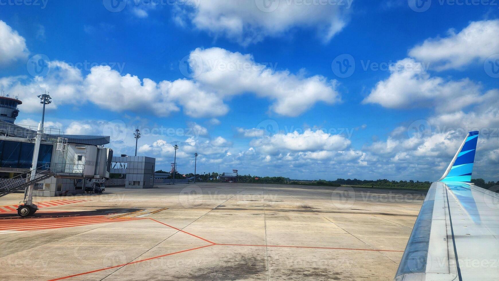 Airport runway with blue sky and white clouds in the background. photo