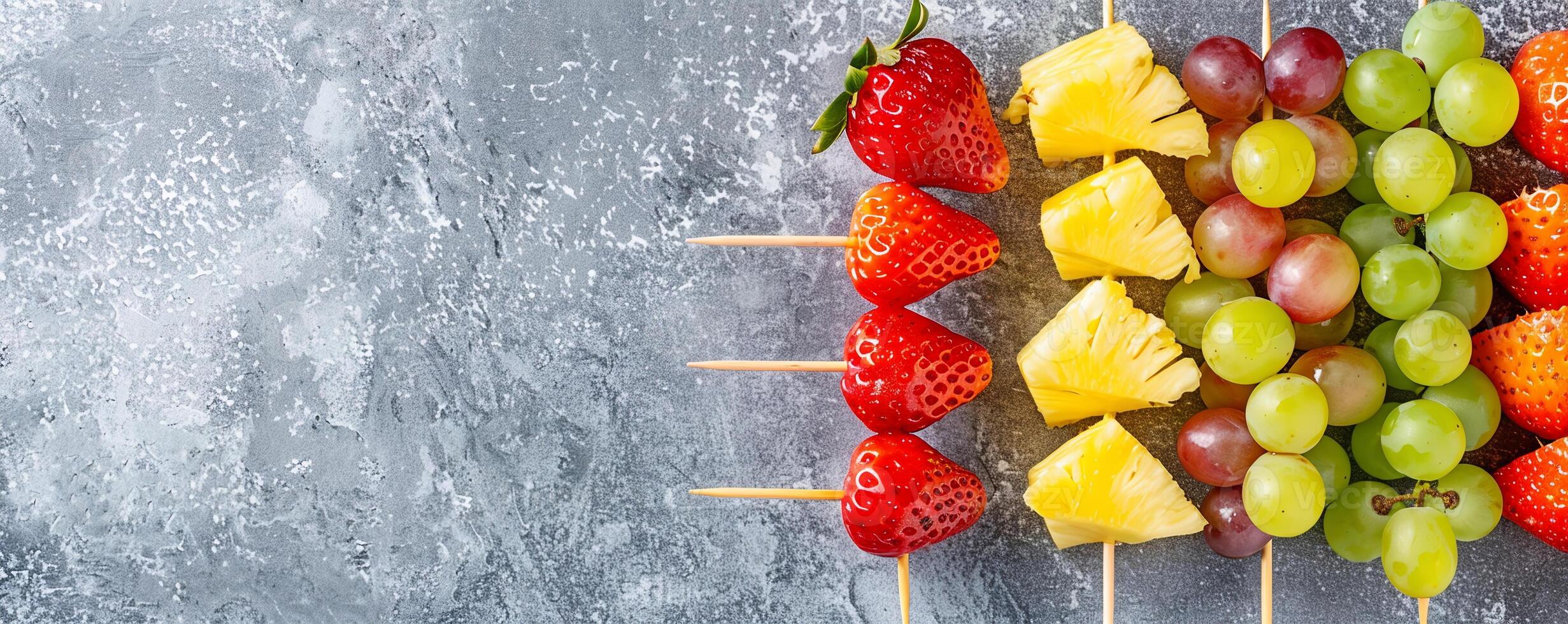 Colorful rainbow fruit skewers with strawberries, grapes, pineapple, and melon balls. photo