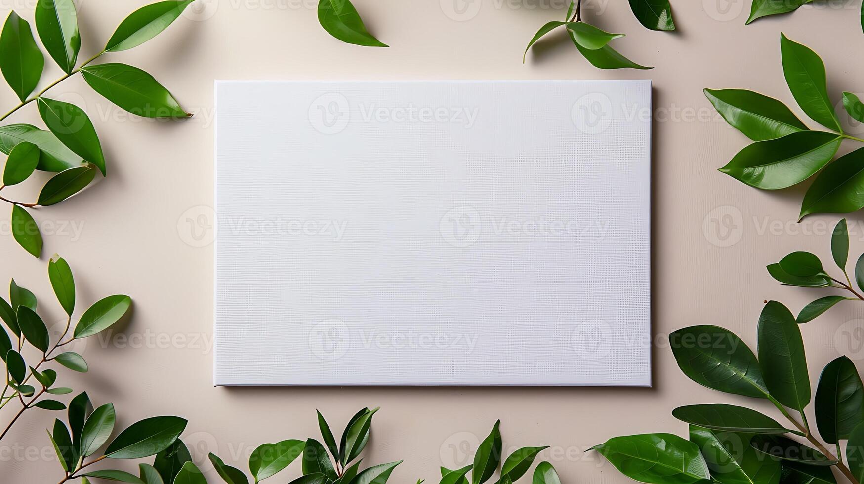 Blank white canvas with green leaves on beige background mockup photo