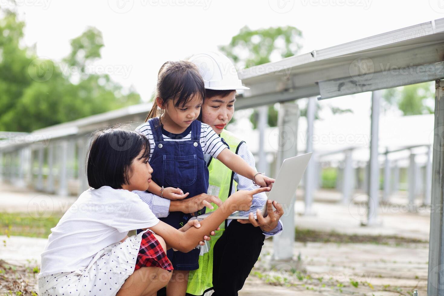Mother and daughter on a solar farm filled with solar panels. Solar energy for future generations resource saving concept Electrical energy sources and alternative energy. photo