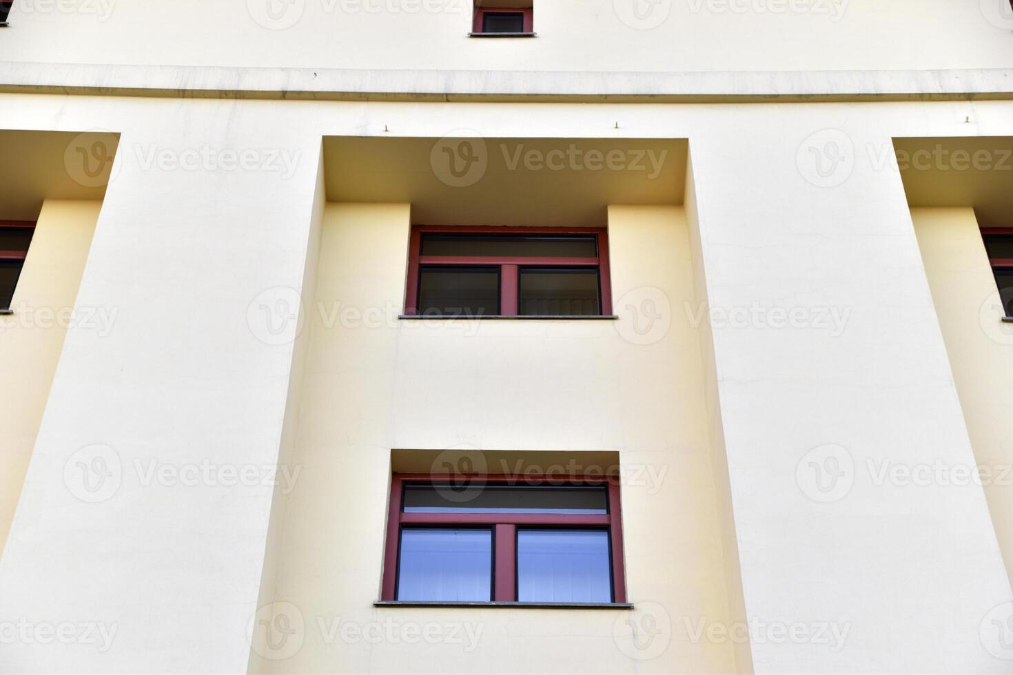 A red window on a yellow wall. A beautiful window in a classic building. photo