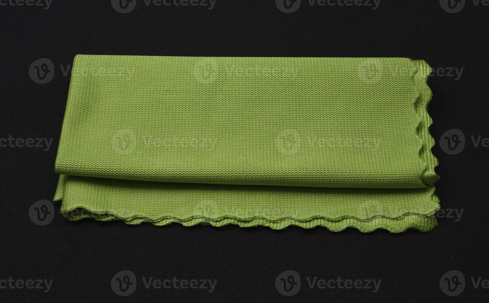 A green cleaning cloth on a black background. photo