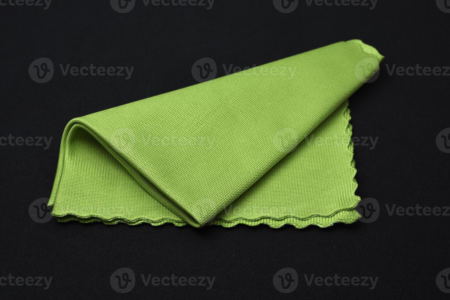 A green cleaning cloth on a black background. photo