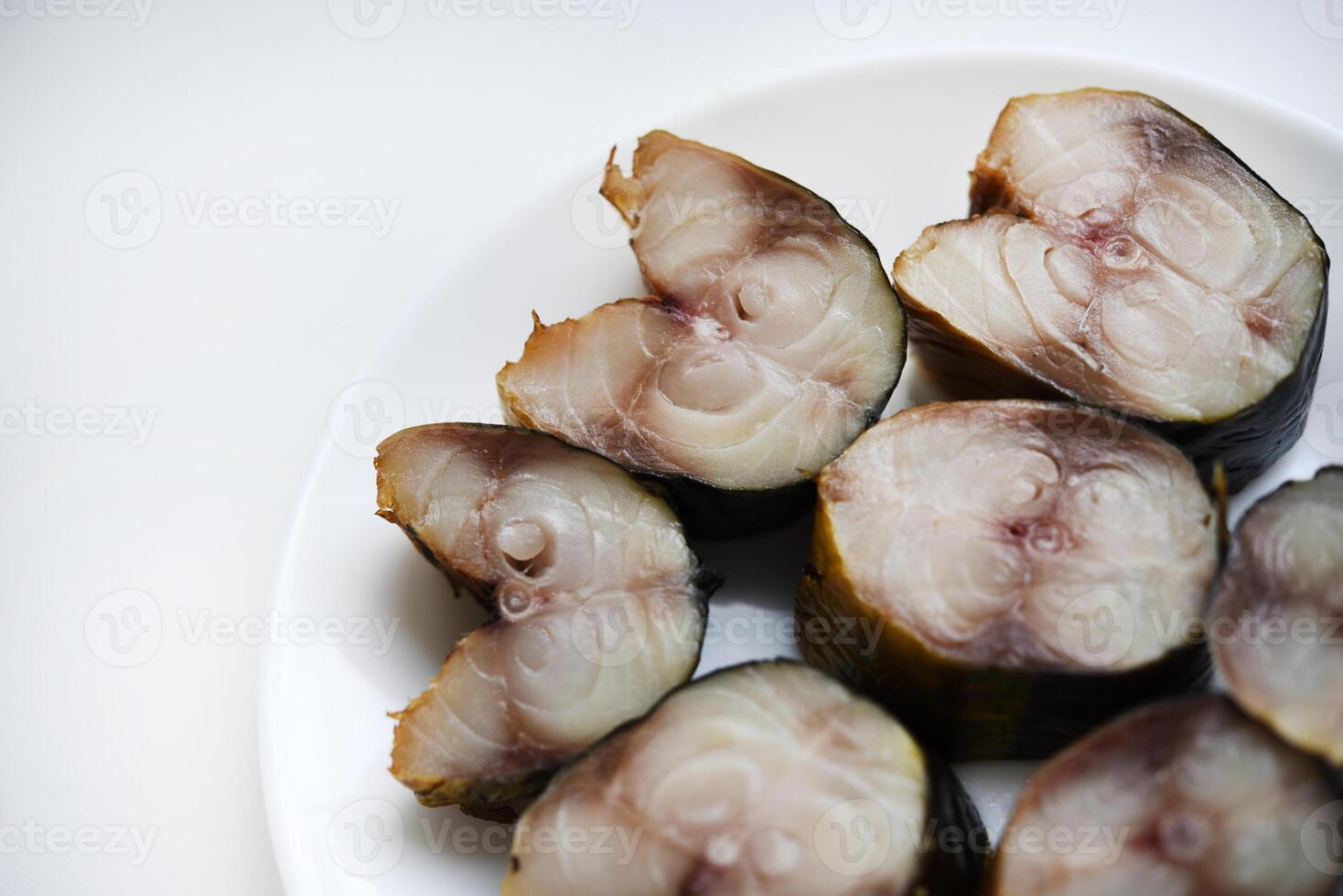 Sliced smoked Scomber on a white plate. Fish appetizer. photo