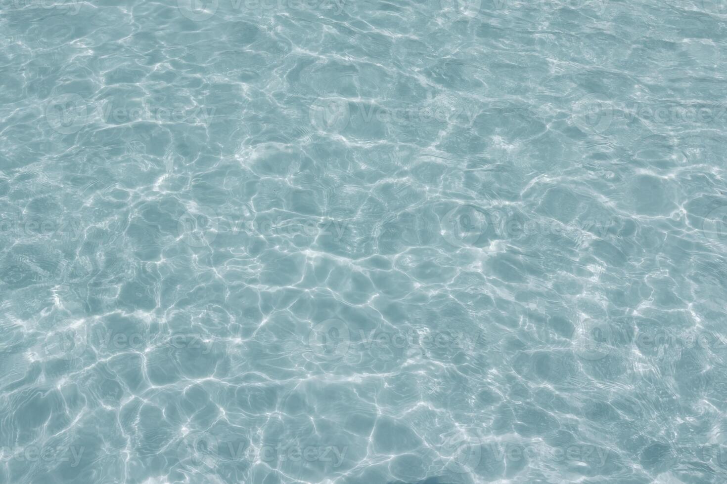 Clear blue water surface with gentle ripples and sunlight reflections. photo