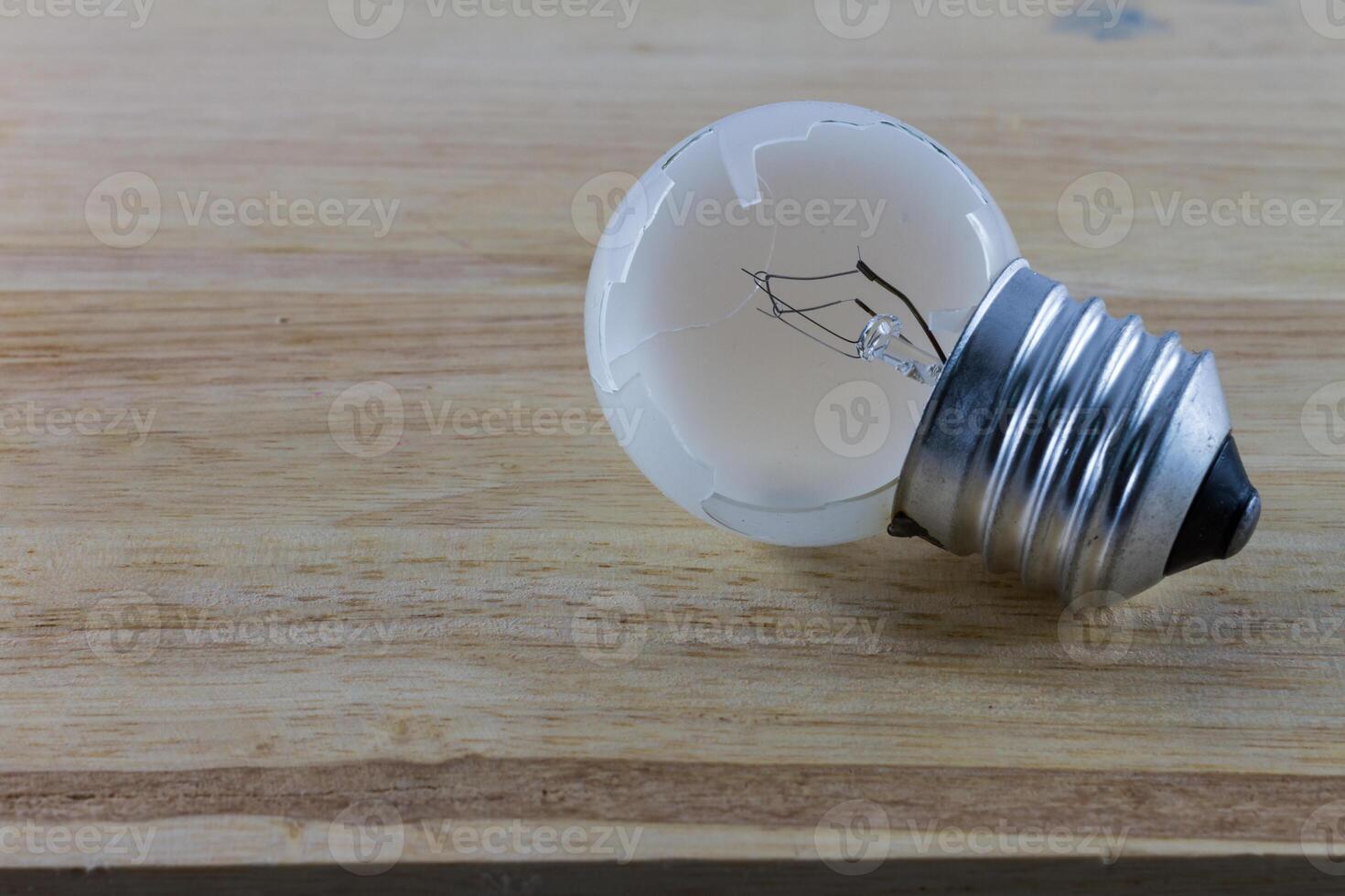 Broken lightbulb on the wood photo