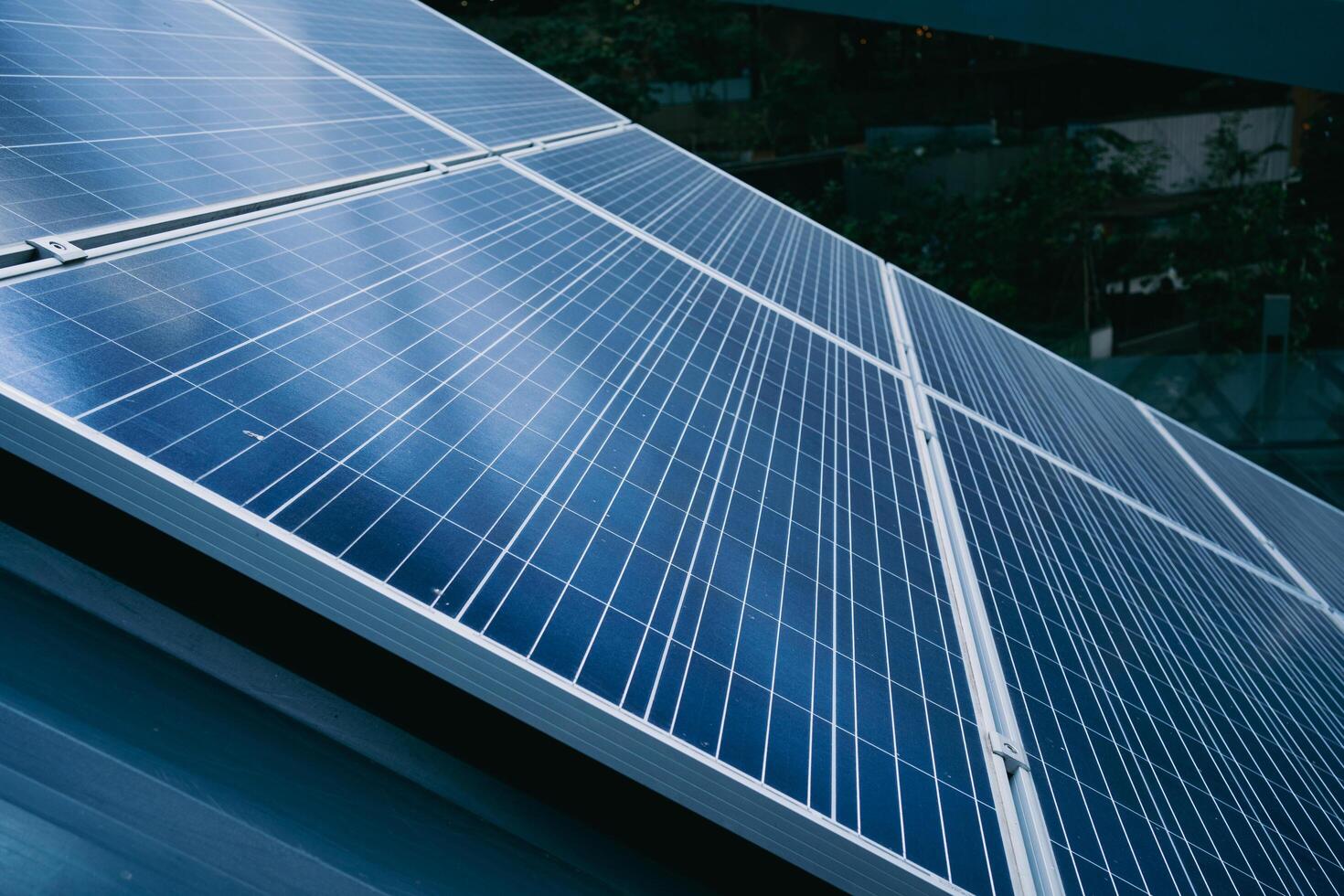 A solar panel is shown in the image, with a blue and silver color scheme. The panel is installed on a roof, and it is a large, multi-panel system photo