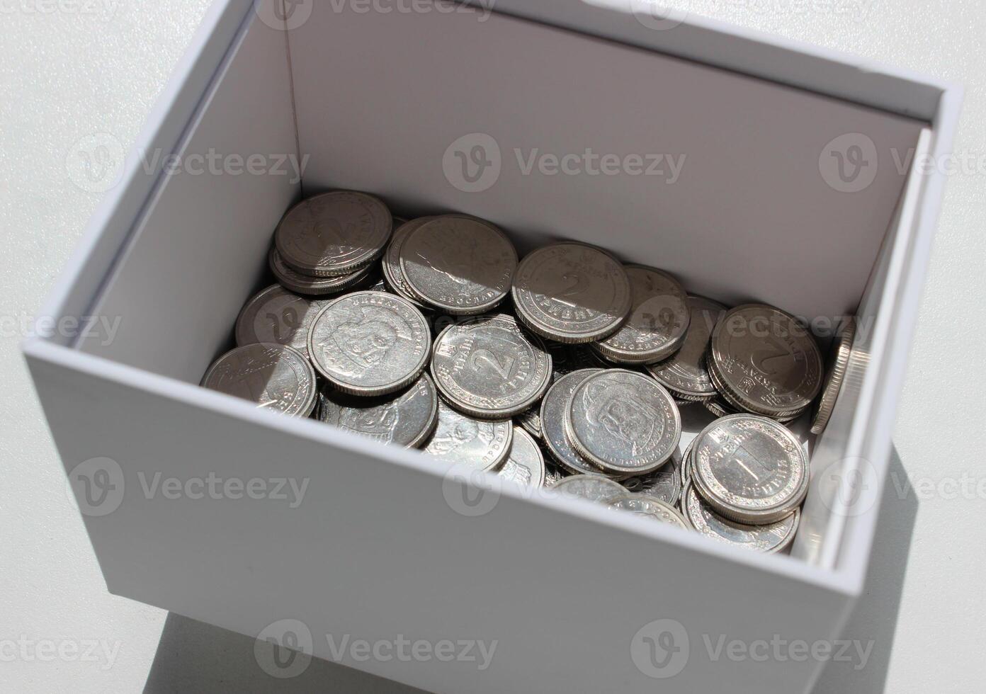 White Box With Ukrainian Silvery Coins On White Surface Stock Photo