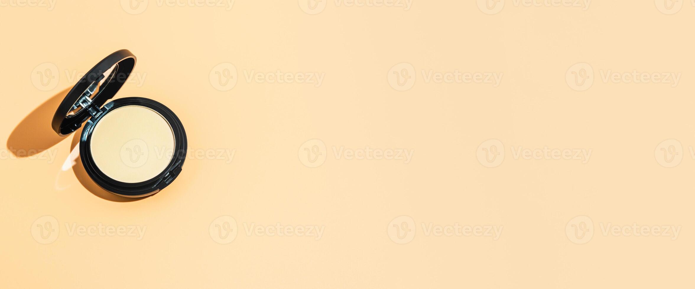 Compact powder on yellow background, copy space photo