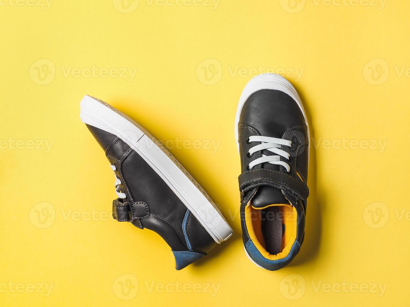 Gray and yellow sneakers on yellow background photo