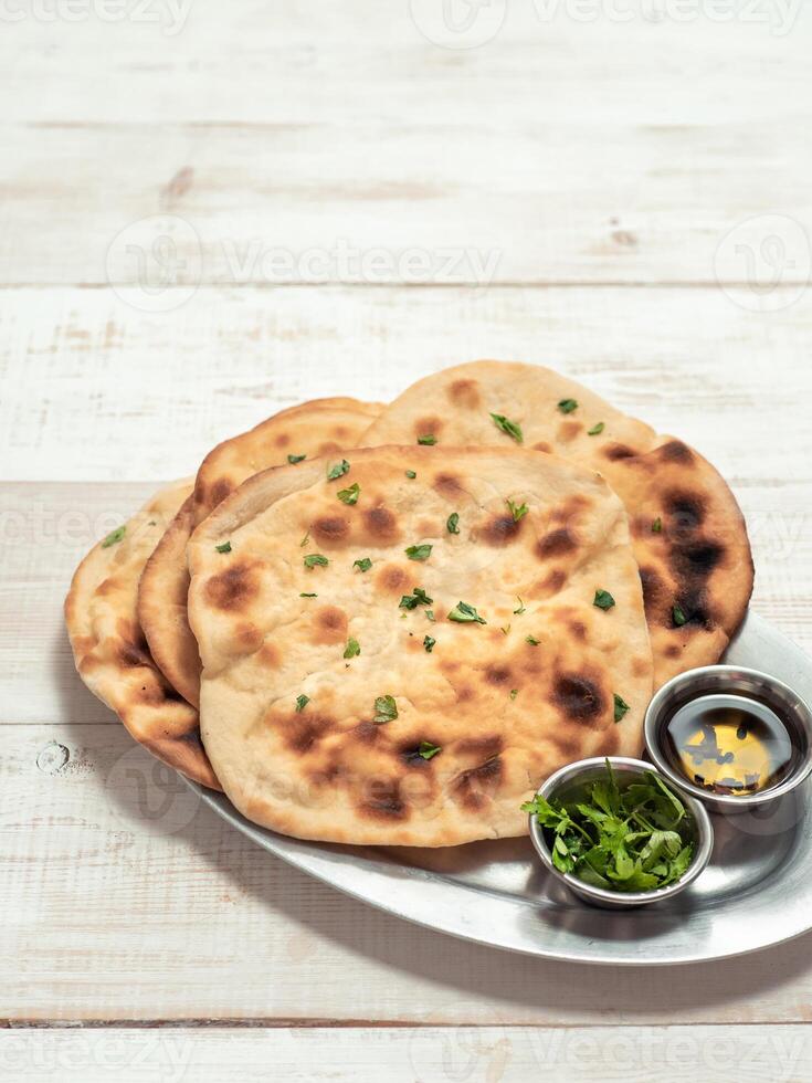 naan flatbreads on white wood, copy space, vertical photo
